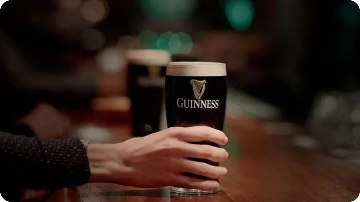 Hand reaching for a pint in a social on-premise setting