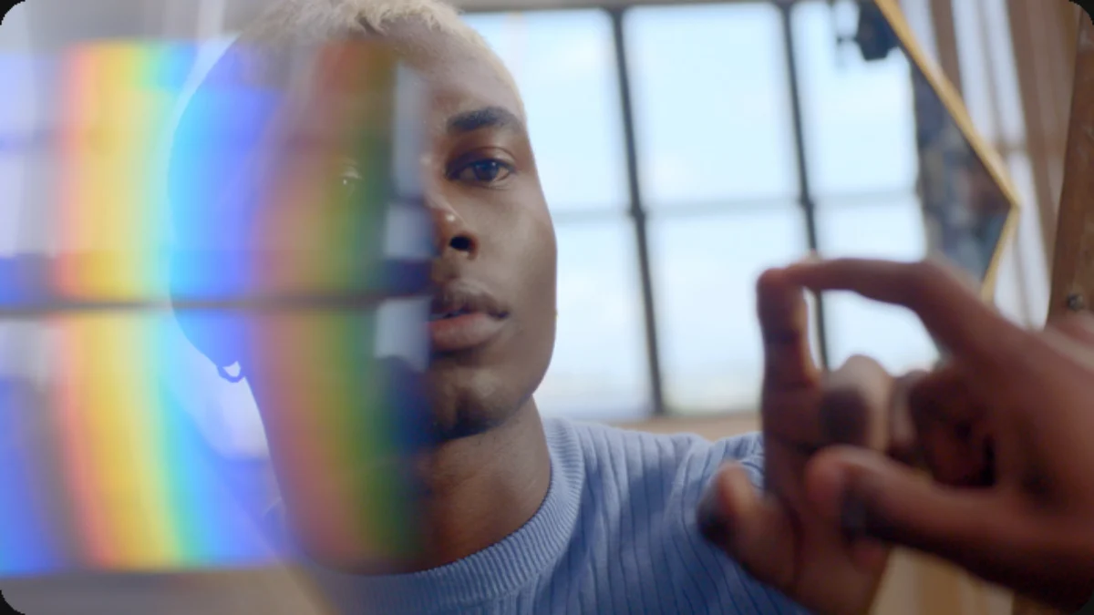 Close-up beauty content scene using a prism to create a rainbow across a person's face