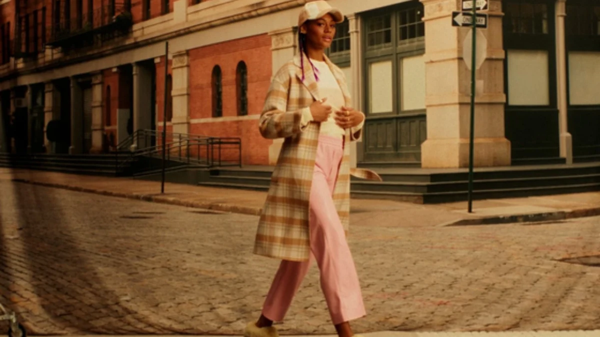 Street-style campaign scene with a model crossing a city street